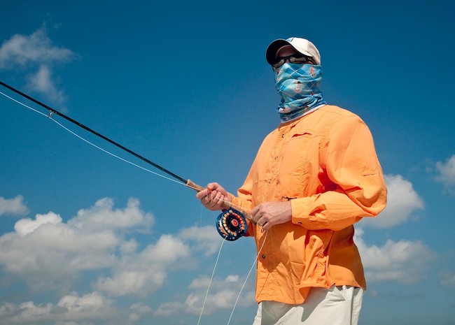 Shane covering the sunny day while flats fishing.