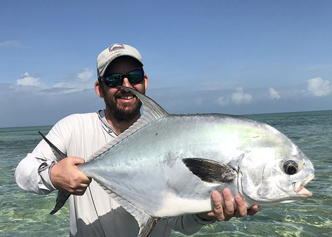 Ernesto showing off to his party the big game he caught in the fly fishing tour.