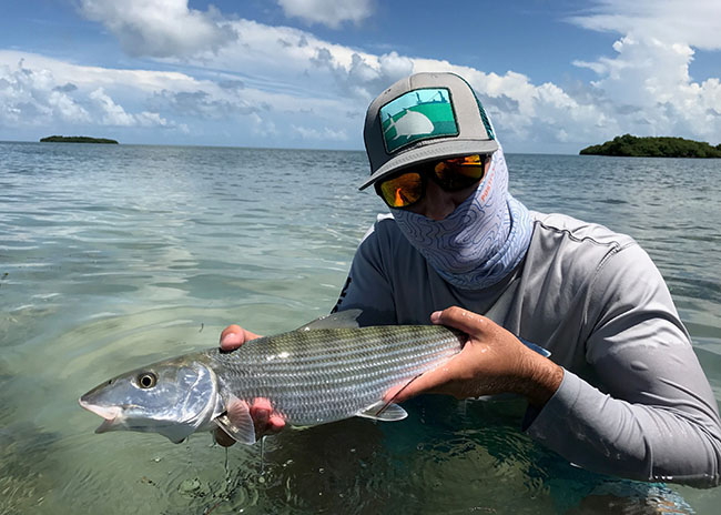 Brent is holding the fish he caught with his fly fishing party in Cozumel.